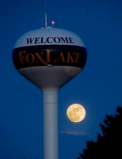 A watertower illuminated by moonlight